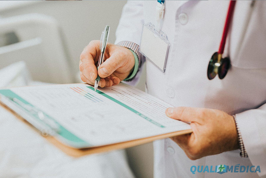 Médico analisando prontuário e resultados de exames como parte de um check-up preventivo e acompanhamento da saúde.