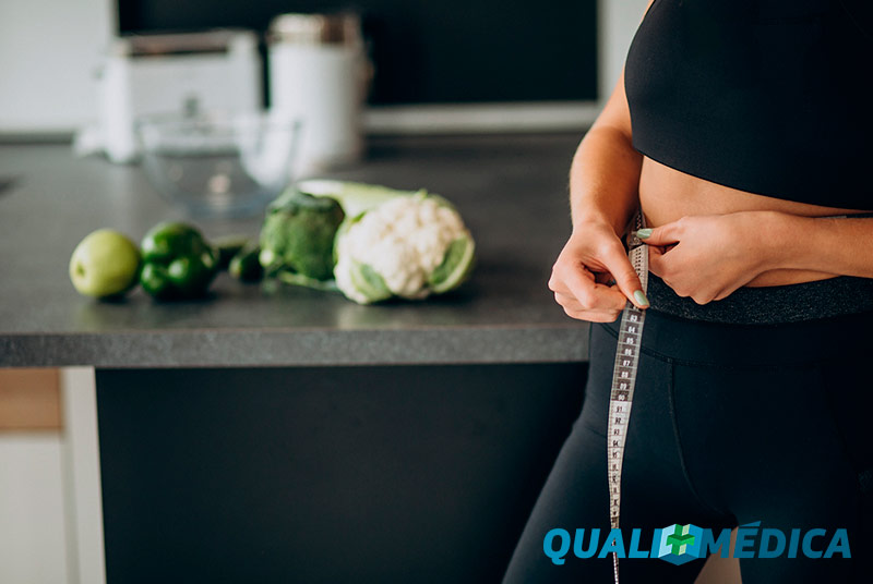 Mulher medindo quadril com fita metrica